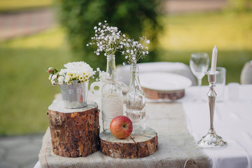 wild flowers in glass bottles and metal buckets on the festive t