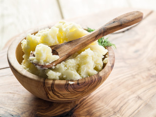Mashed potatoes in the wooden bowl on the service tray.