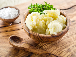 Mashed potatoes in the wooden bowl on the service tray.