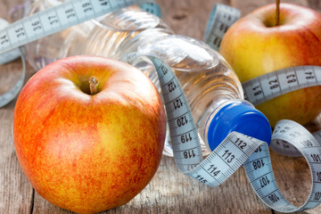 Bottle of water, measuring tape and apples