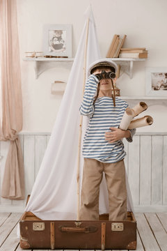 Boy in the image of sailor playing in her room