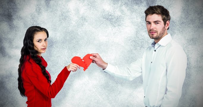 Composite image of portrait of couple holding red cracked heart 