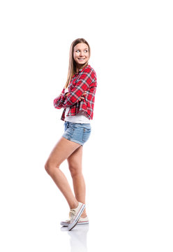 Girl in shorts and checked shirt, arms crossed, isolated