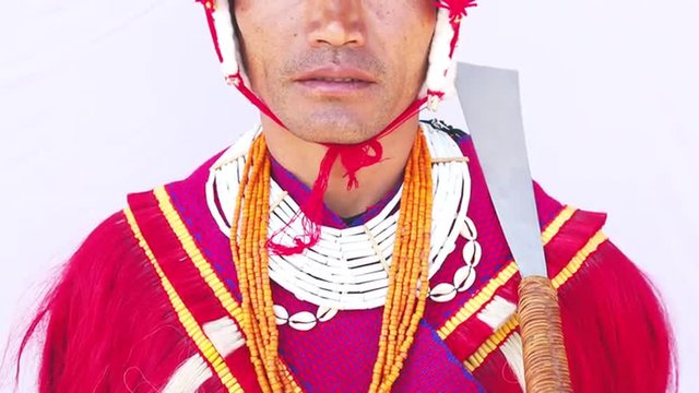 Tilt up shot of a Naga tribesman in traditional outfit during Hornbill Festival, Kisama, Kohima, Nagaland, India