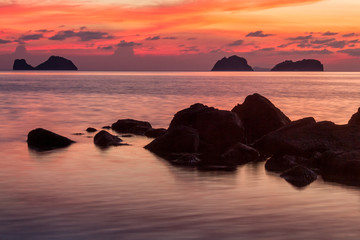 Colored sunset over the tropical sea, stones and cliffs 