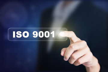 Businessman pressing a ISO 9001 concept button. Can be used in advertising.