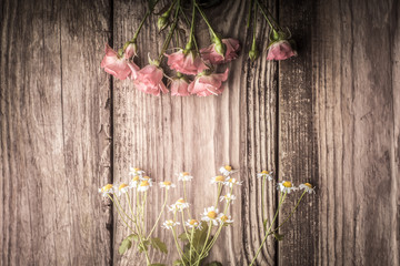 Obraz na płótnie Canvas Roses and daisies on a wooden table