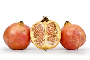 Fruits of pomegranate (Punica granatum) with cross section one of them on white background. Clipping path incl.
