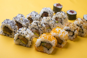 Various kinds of sushi food served on yellow blackground