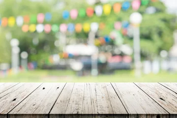 Tuinposter Empty wooden table with blurred party on background © Akura Yochi