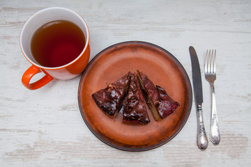 Piece of homemade tart with caramel filling on a clay plate