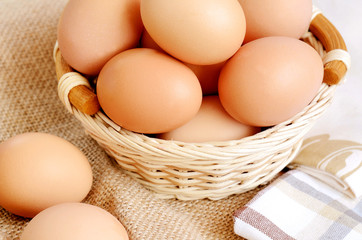 Wicker basket with eggs on a linen tablecloth