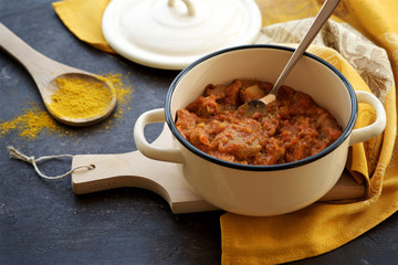 Meat curry in a pot on dark background