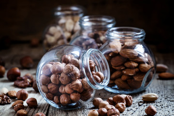 Hazelnut in a glass jar, dark toned image, selective focus