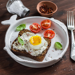 Healthy food - open sandwich with rye bread, soft cheese and boiled egg. On a light rustic wood surfaces. Healthy Breakfast or snack