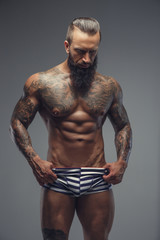 Fototapeta premium Naked bearded man with tattooed body.