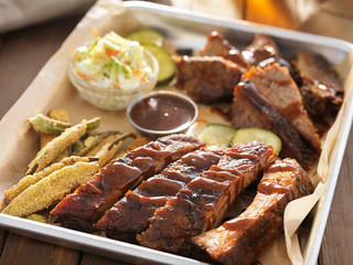 smoked beef brisket witth barbecued ribs in platter and fixings