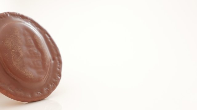 Chocolate glazed orange biscuits on white background slow panning 4K 2160p UltraHD close-up footage - Slow panning over biscuit on white reflective surface 4K 3840X2160 UHD video 