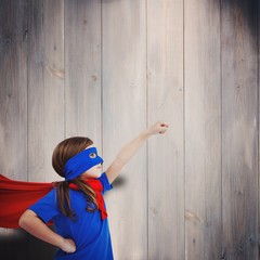 Composite image of masked girl pretending to be superhero