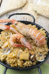 Vegetable paella with seafood on a wooden background