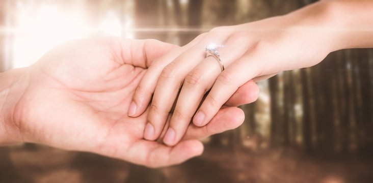 Composite image of close-up of couple holding hands