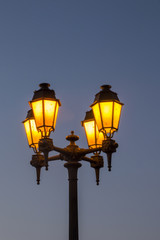 Fototapeta na wymiar View of typical european streetlight lit at twilight.