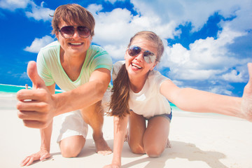 close up of happy young caucasian couple in sunglasses smiling on beach