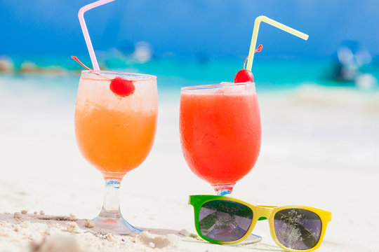 Exotic cocktails and sunglasses, caribbean beach on background