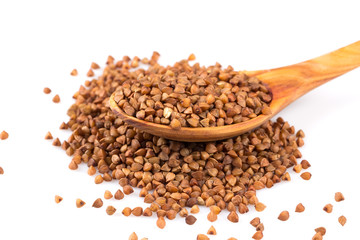 Uncooked buckwheat on wooden spoon