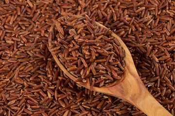 Red rice in a wooden spoon