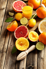 Citrus fruits with juicer on a brown wooden table
