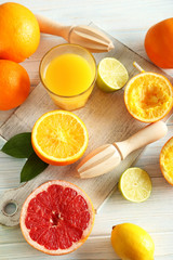 Naklejka na ściany i meble Citrus fruits with juicer on a blue wooden table