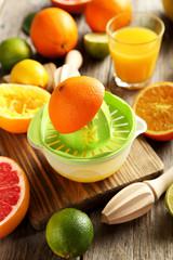 Citrus fruits with juicer on a grey wooden table