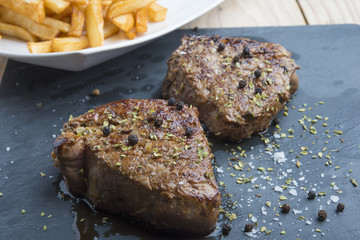 cooked beef chateaubriand steak with chunk chipped potatoes on p