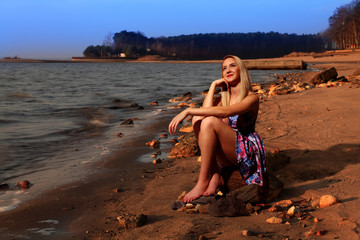 Blondynka na brzegu jeziora, zachód słońca.