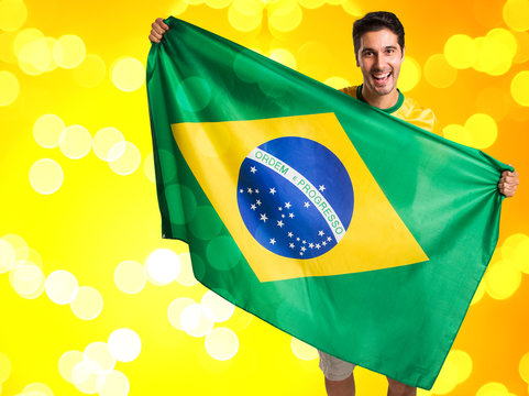 Brazilian fan celebrates on yellow background