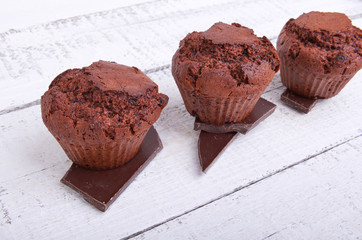 Baked chocolate muffins cakes on a plate on white