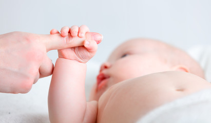 Fototapeta na wymiar concept of parental love. baby hand holding finger of mother