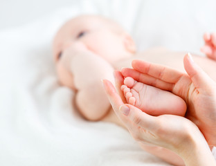 Fototapeta na wymiar feet newborn baby in arms him mother