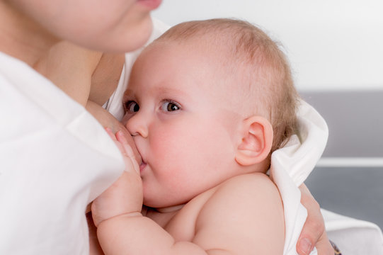 Portrait of a little girl. Baby feeds on MOM's breasts