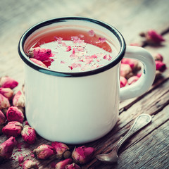 Rose buds tea in tea cup. Retro toned.