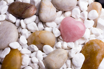 Pink heart stone on the spa stone background.