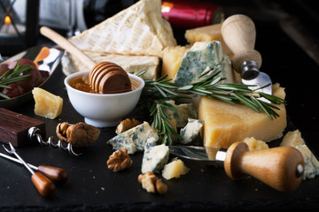 Delicious cheeses on a board with honey, nuts and wine - 102964833