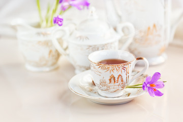 Obraz na płótnie Canvas cup of tea or coffee and crocus flowers