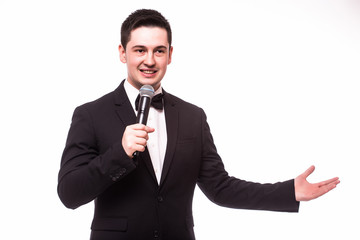 Young elegant talking man holding microphone and present invisible product. Isolated on white.Showman concept.
