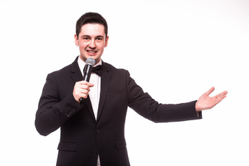Young elegant talking man holding microphone and present invisible product. Isolated on...