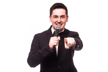 Young elegant talking man holding microphone talking with pointing finger. Isolated on white...
