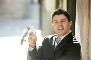 busy businessman in suit and tie using mobile phone sending message or consulting internet