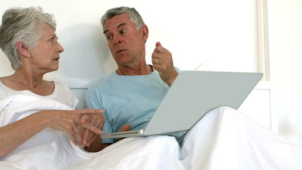 Senior couple using laptop together - Powered by Adobe