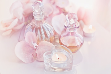 Fototapeta na wymiar perfume and aromatic oils bottles surrounded by flowers and candles
